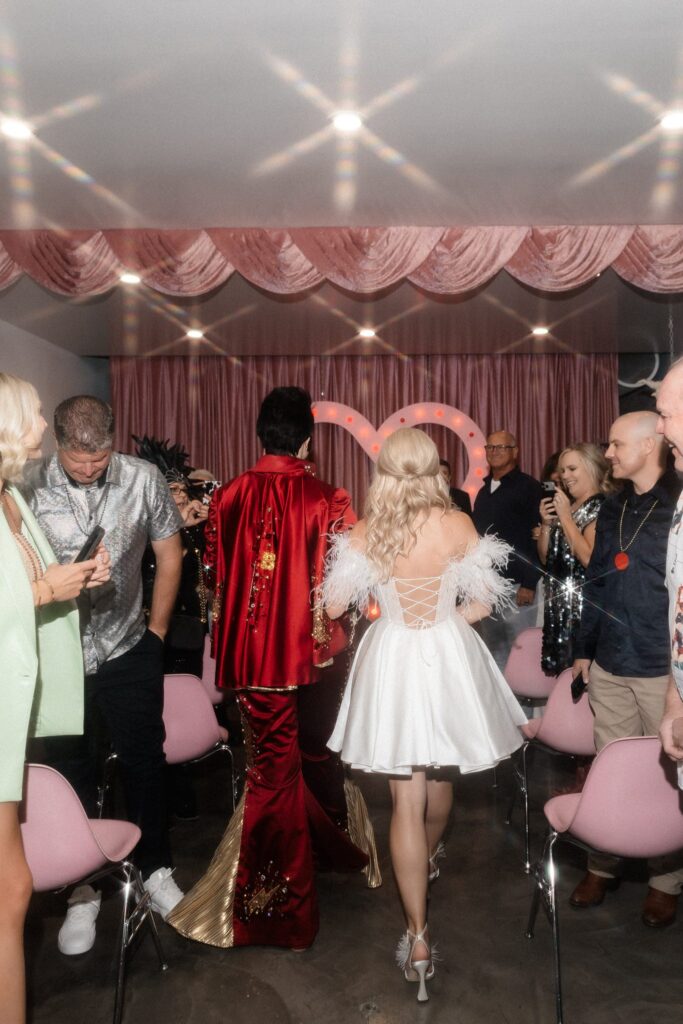 Bride being walked down the aisle by Lady Elvis.