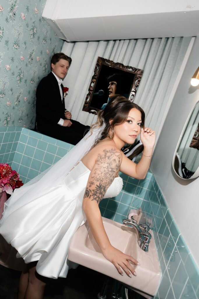 Bride and groom posing in the baby blue bathroom at Sure Thing Chapel in Las Vegas.