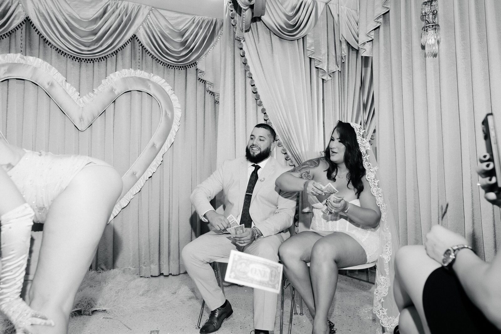 Black and white photo of a couple throwing dollar bills during a Showgirl performance at Sure Thing Too in Las Vegas.