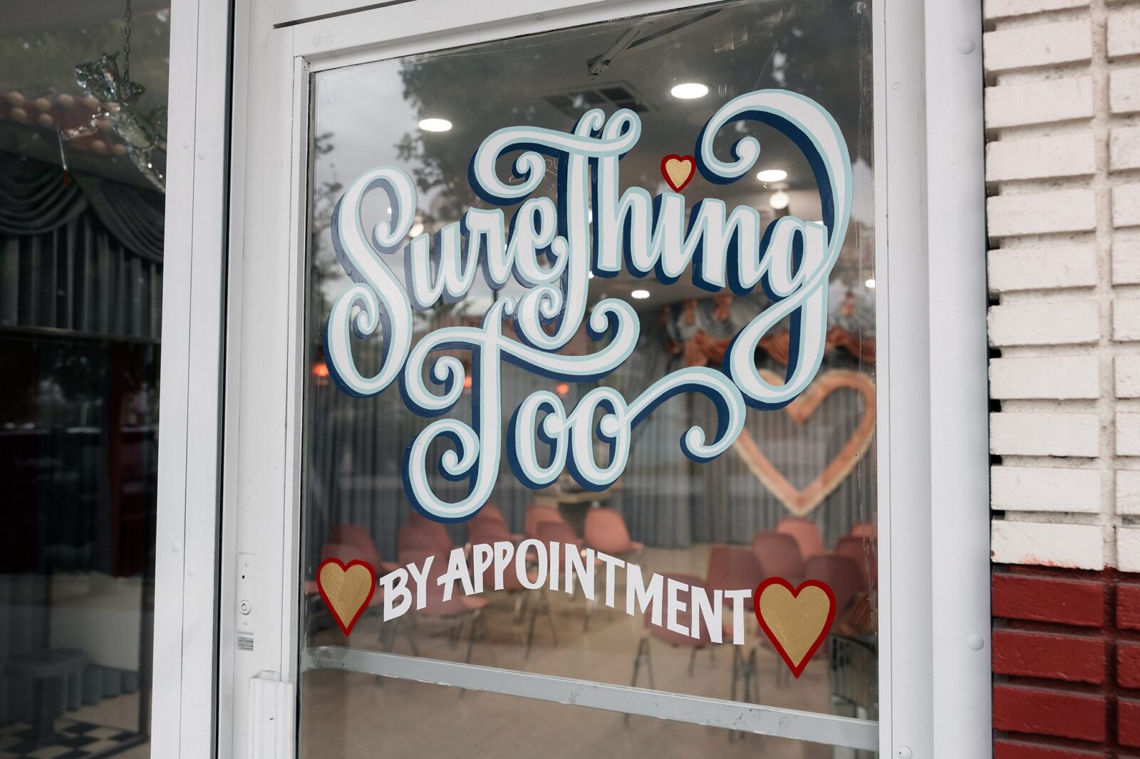 The Sure Thing Too door sign that says by appointment.