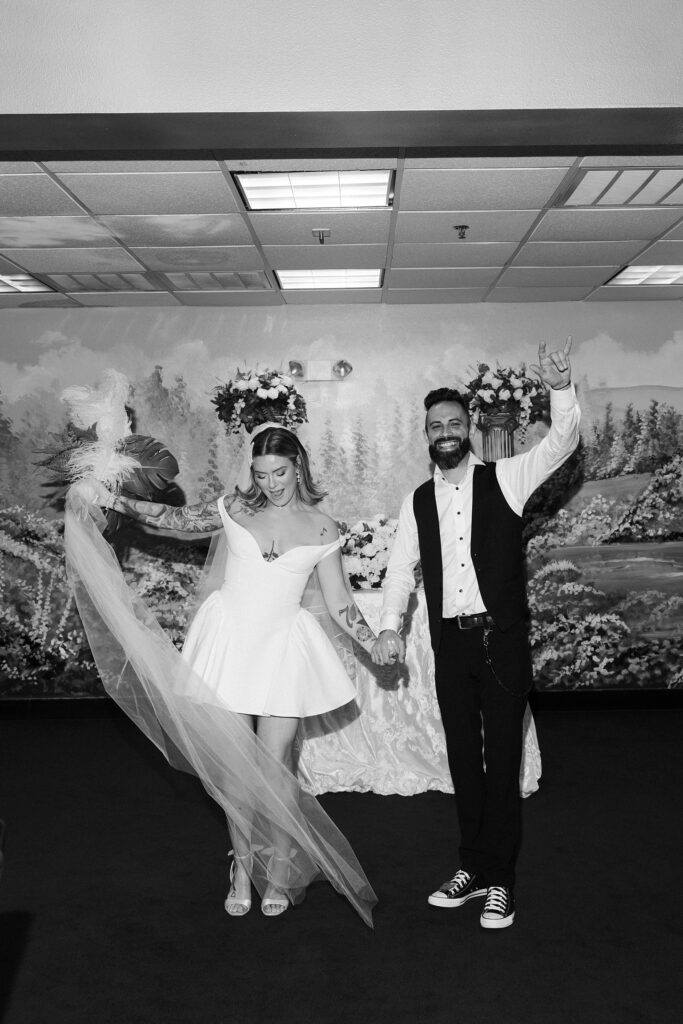 Bride and groom holding their hands up in the air and celebrating after their Chapel Amore Las Vegas wedding ceremony.