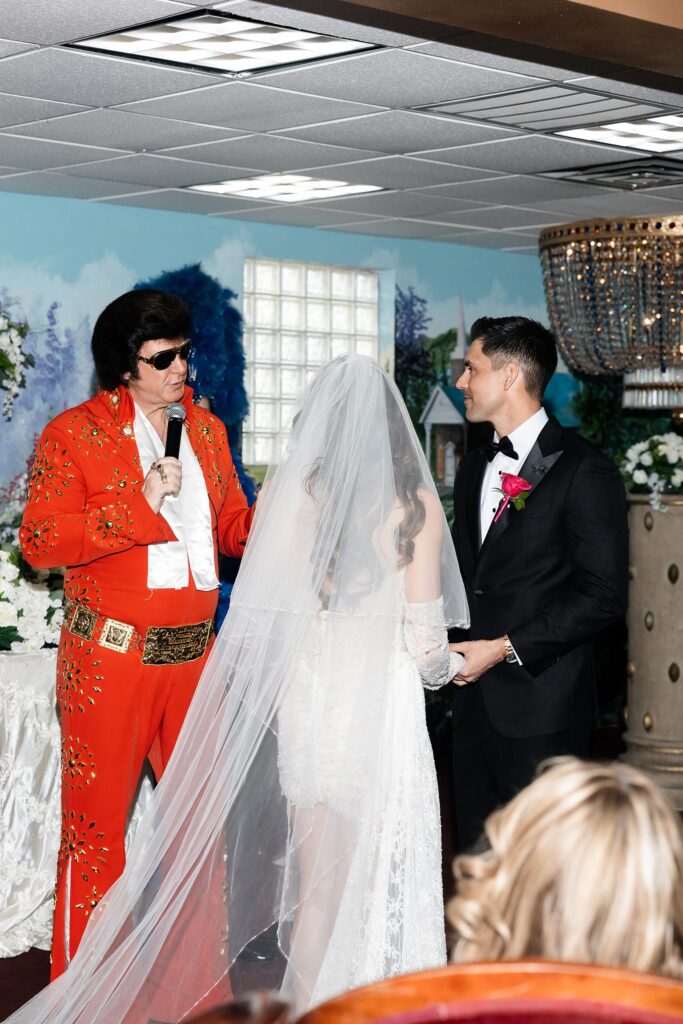 Bride and groom holding hands during their Chapel Amore Las Vegas wedding ceremony. 