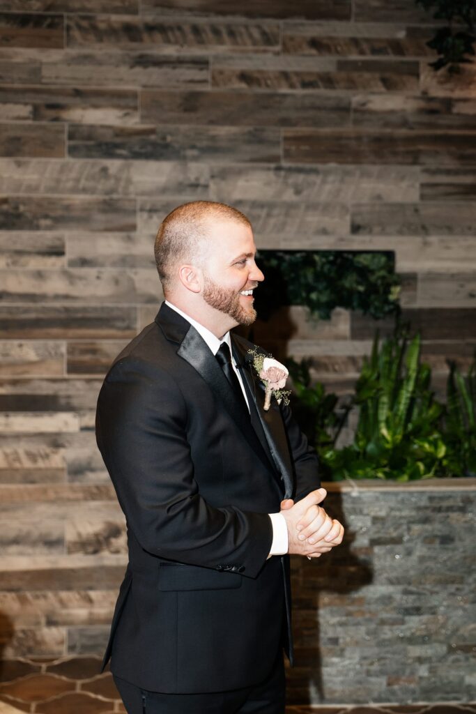 Groom watching his bride walk down the aisle during their Chapel of Flowers wedding