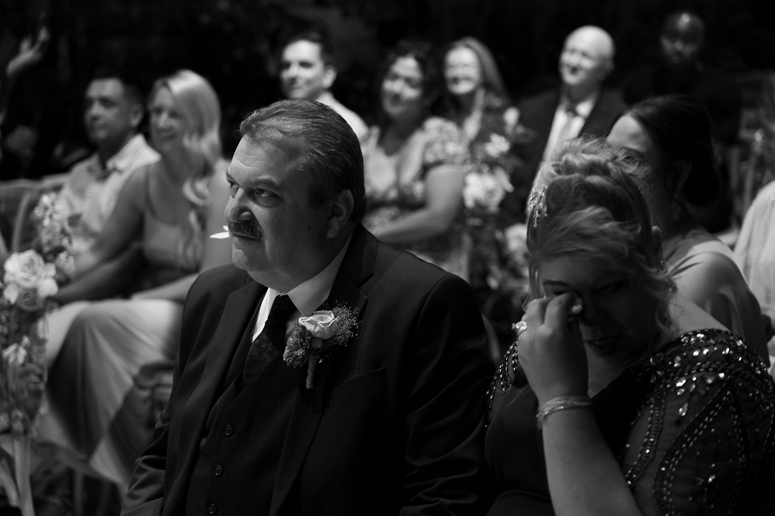 Black and white photo of a guests getting emotional during the Chapel of Flowers wedding ceremony