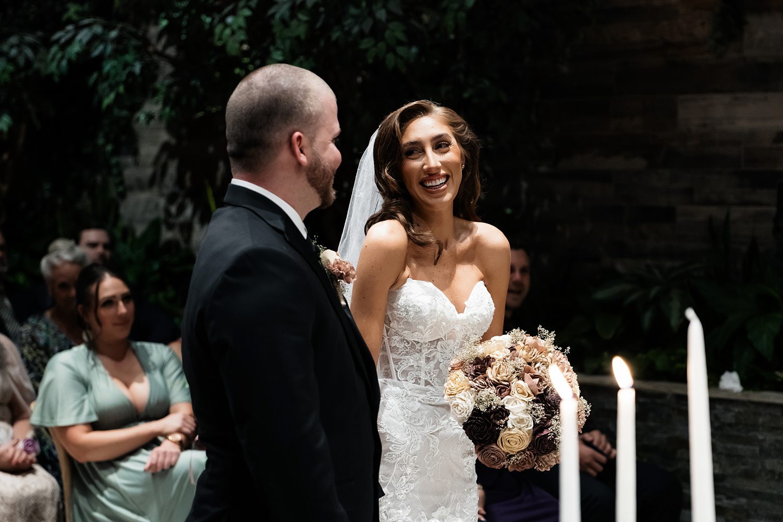 Bride and groom smiling at each other during their Chapel of Flowers wedding ceremony in The Glass Gardens