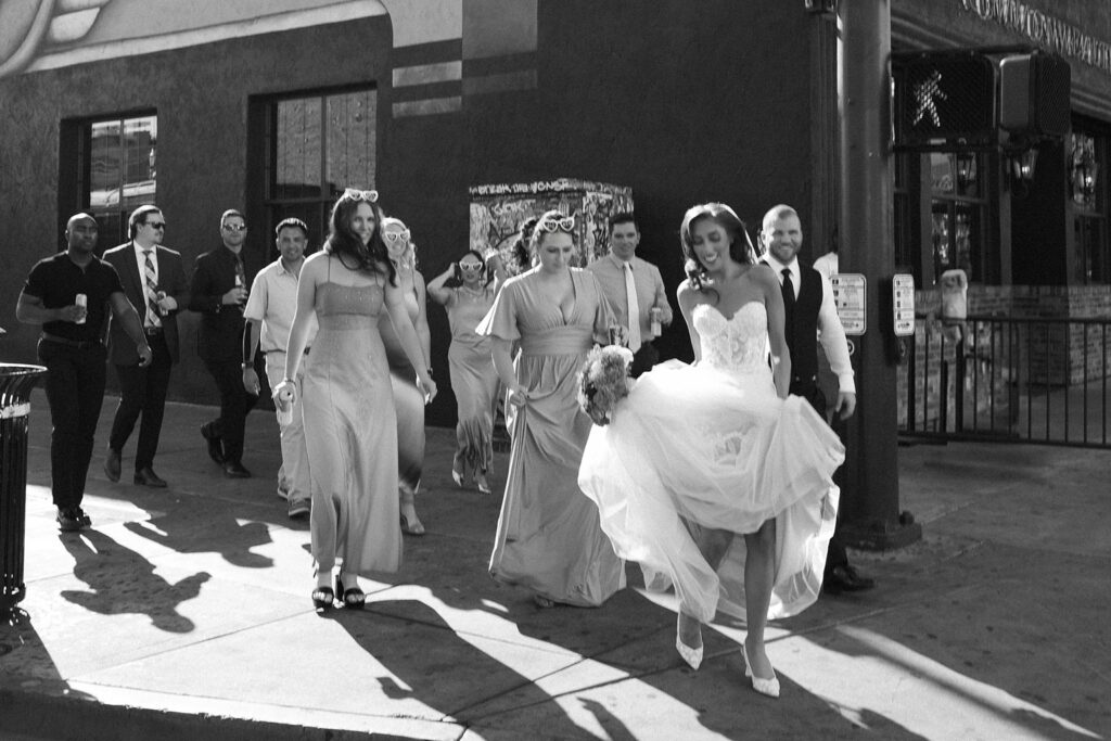 Black and white photo of the wedding party walking on Fremont Street