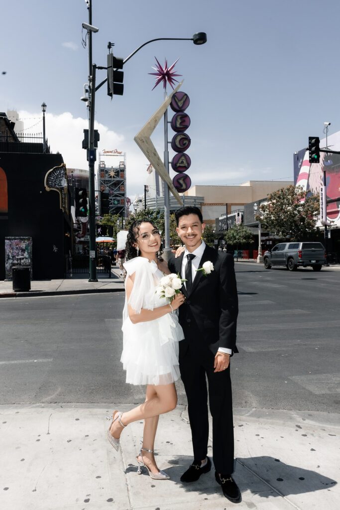 Bride and groom posing in front of the Vegas sign on Fremont Street