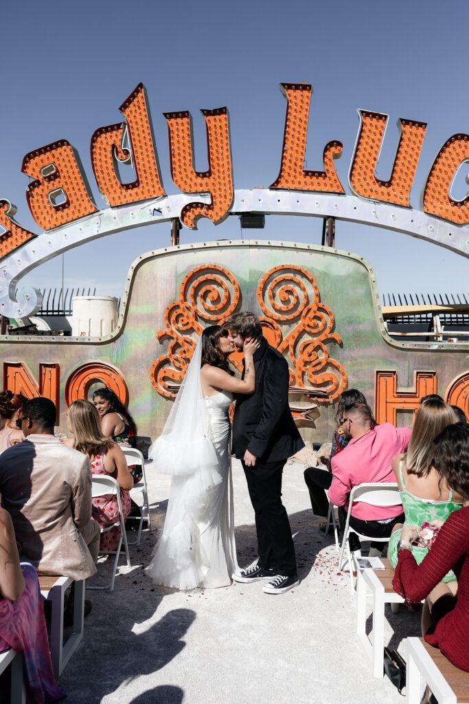 Bride and groom kissing at the end of the aisle