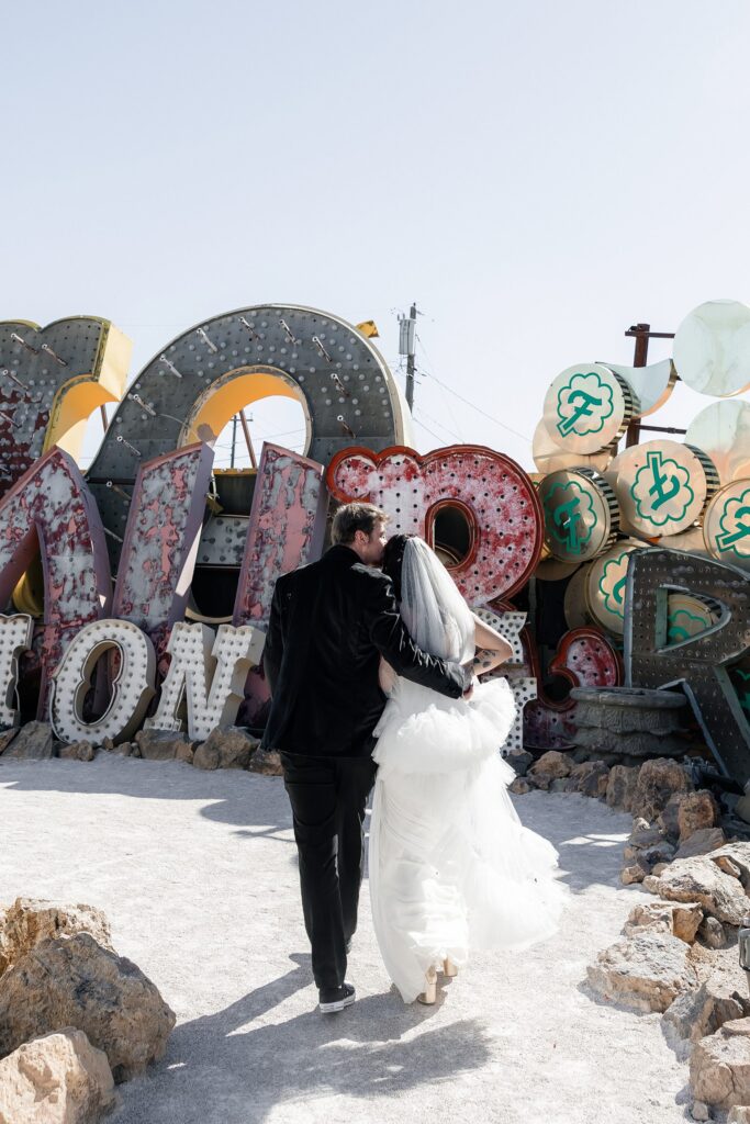 Bride and groom walking away together after their Neon Museum wedding ceremony