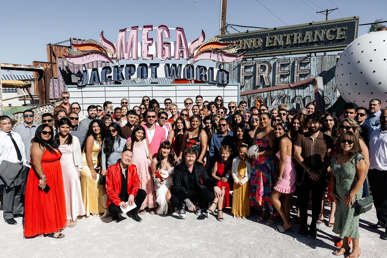 Bride and groom posing with their guests after their Las Vegas Neon Museum wedding