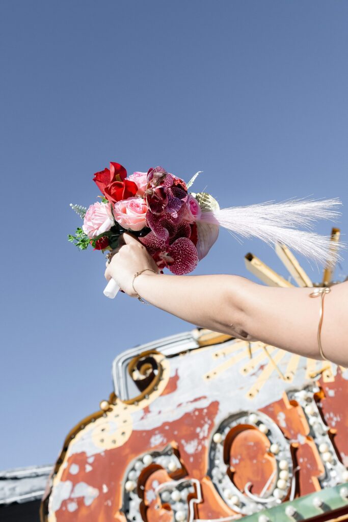 Bride holding her colorful Las Vegas wedding bouquet up to the sky