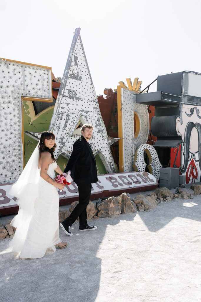 Bride and groom walking through the Neon Museum for their wedding photos