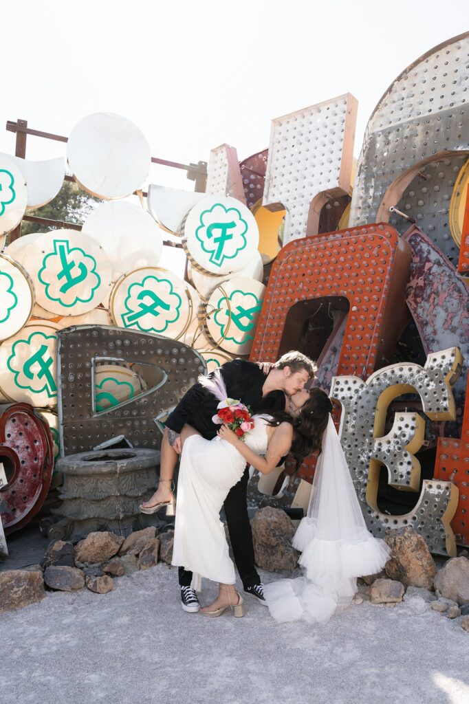 Bride and groom kissing at The Neon Museum