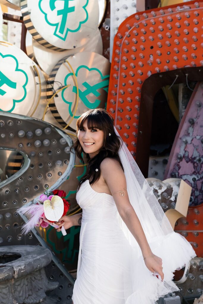 Bride posing for her Neon Museum wedding photos wearing a BHLDN Watters Lupine Wedding Dress