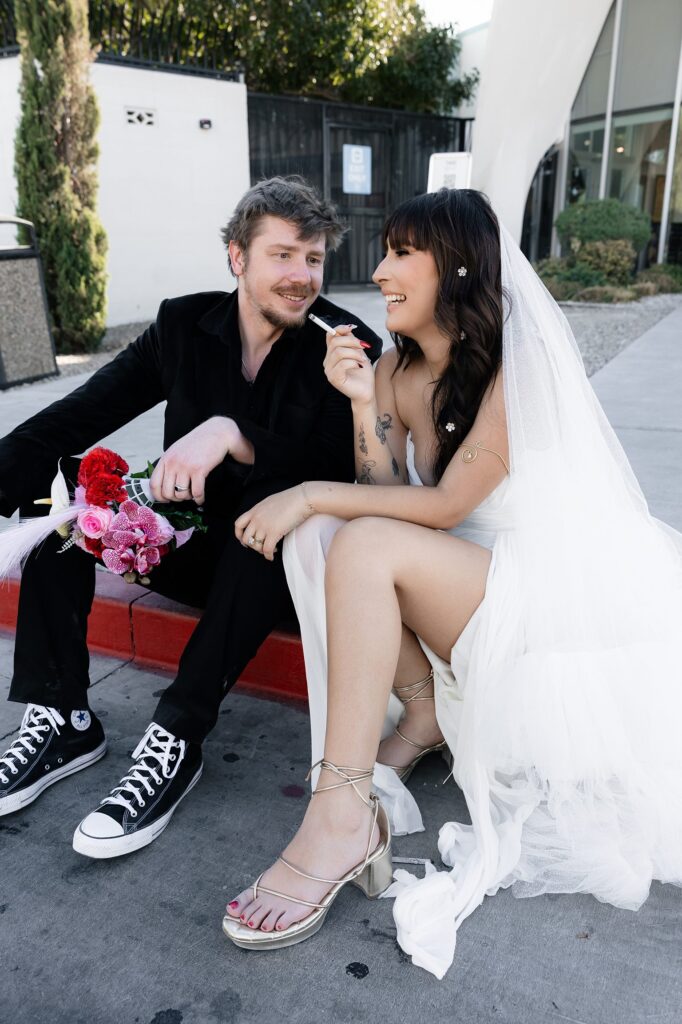 Bride and groom smoking a cigarette outside of The Neon Museum Las Vegas