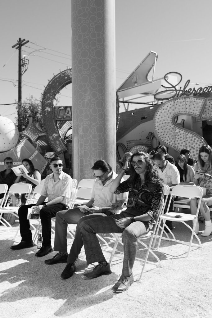 Black and white photo of wedding guests seated for the ceremony