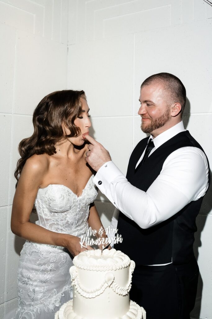 Bride and groom trying their wedding cake