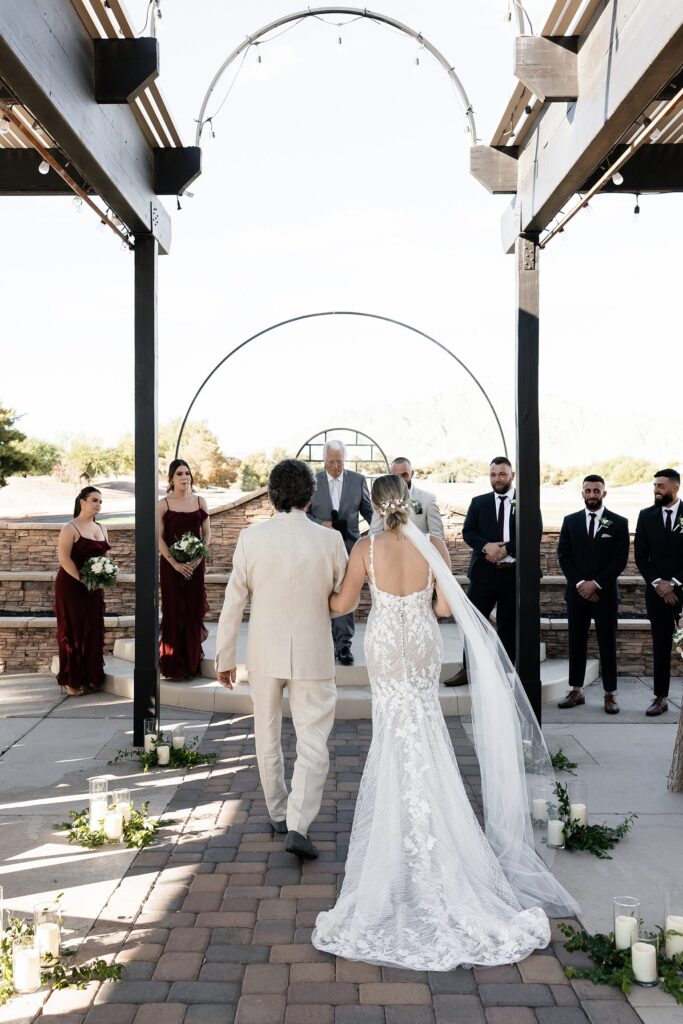 Bride being walked down he aisle during her outdoor Stallion Mountain wedding ceremony on The Patio