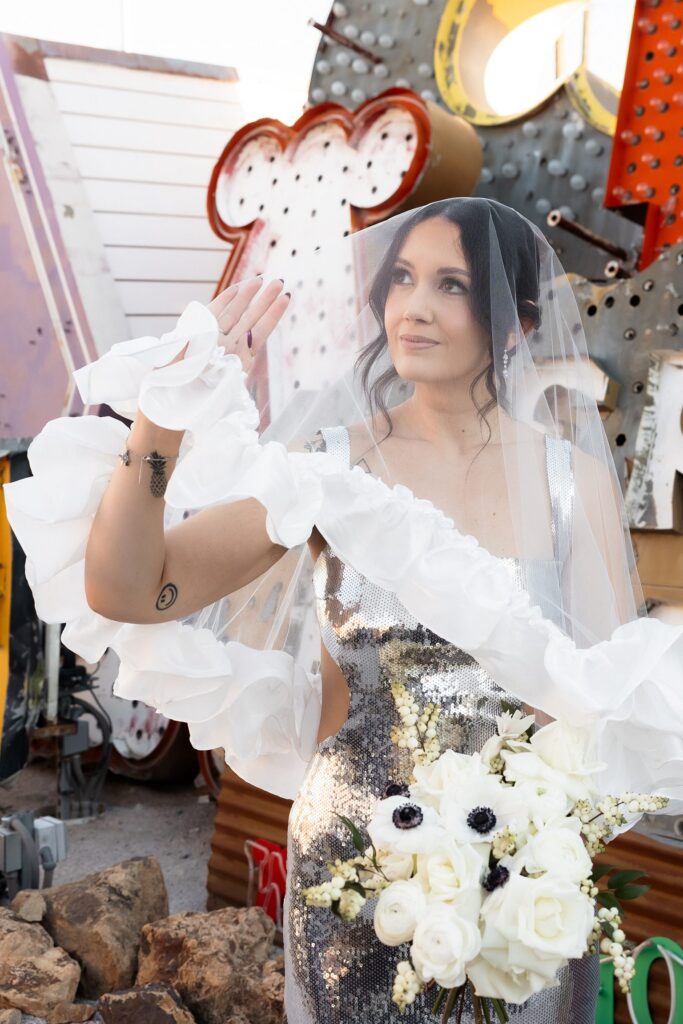 Bride posing under her veil for her Neon Museum wedding portraits in Las Vegas