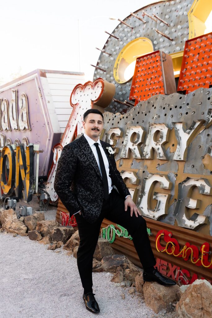 Groom posing for his Neon Museum wedding portraits in Las Vegas