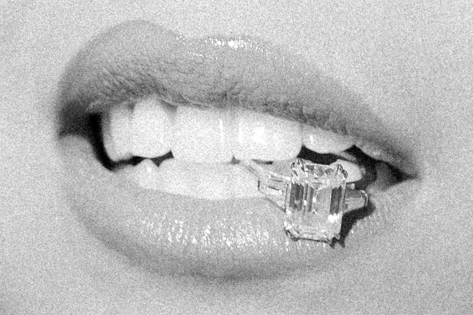 Black and white photo of a bride biting on a ring