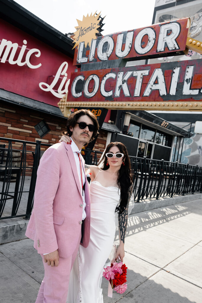 Couple posing for their Las Vegas elopement photos outside of Atomic Liquors 