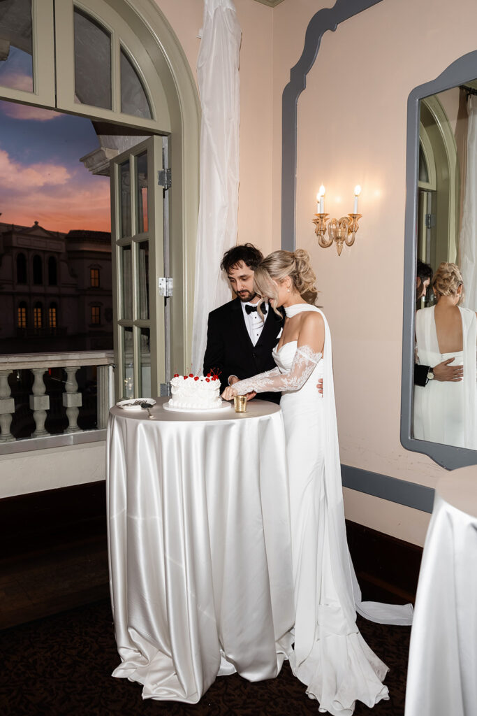 Bride and groom cutting into their wedding cake for their Canaletto reception 