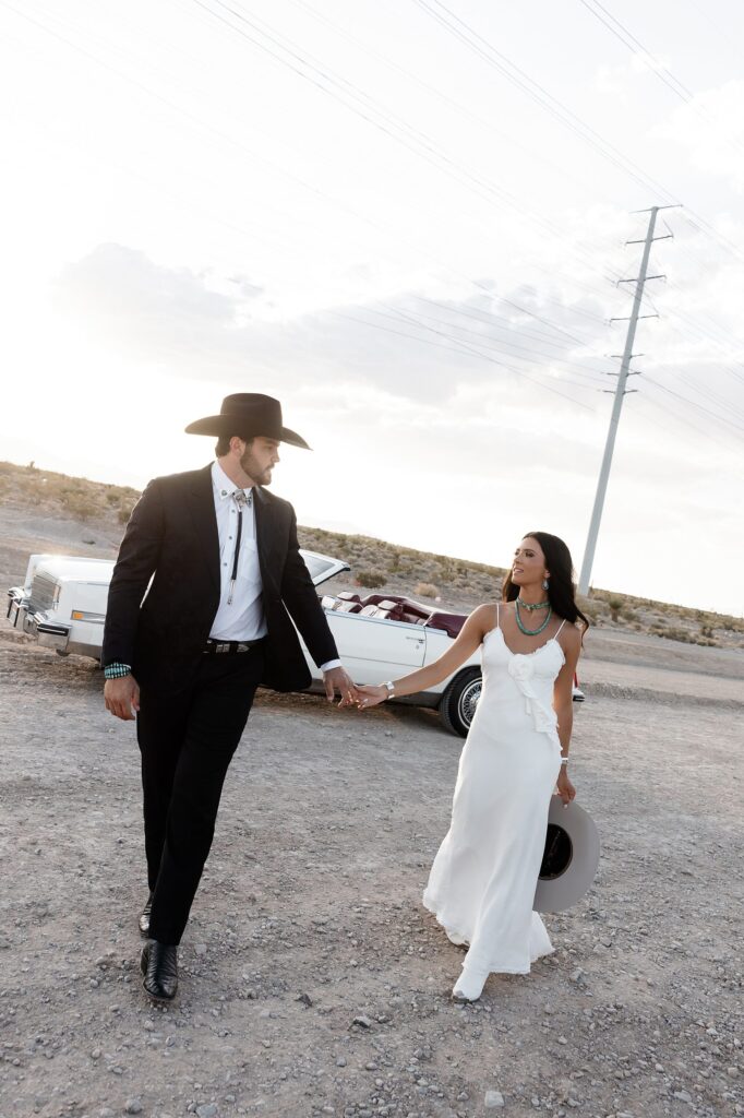 Las Vegas desert engagement photos with a couple walking toward the camera in bold, fashion-forward outfits.