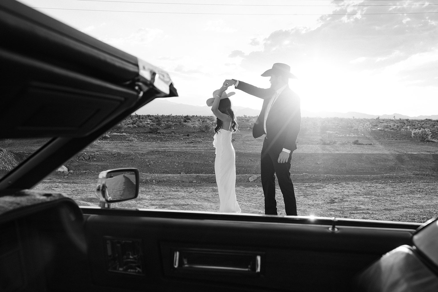 Black and white photo of a couple dancing in the desert for their western engagement photos in Las Vegas