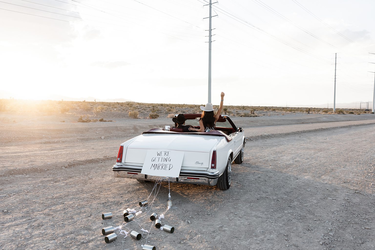 Couple riding off in a car and a "We're Getting Married" sign on the back