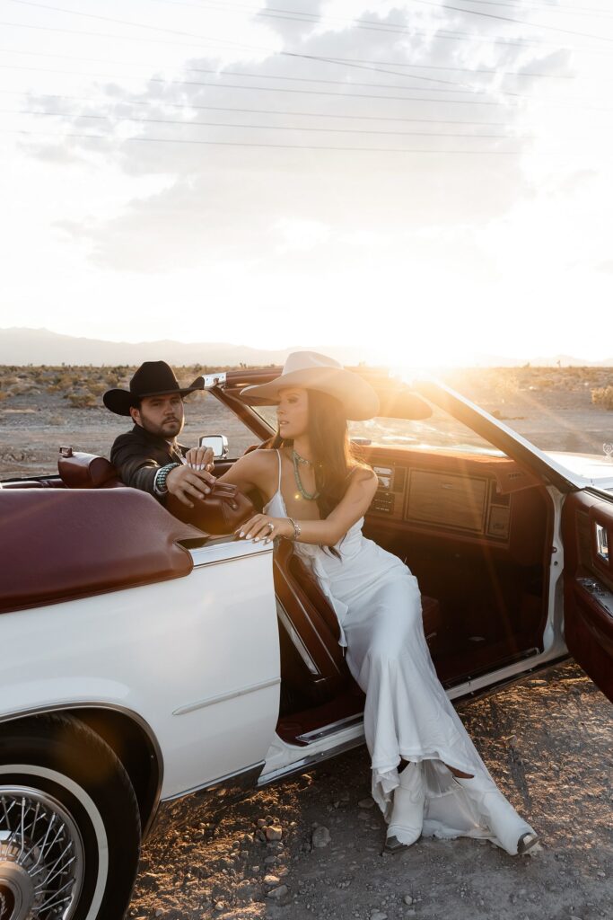 Couple posing in a car during golden hour for their western engagement photos in Las Vegas