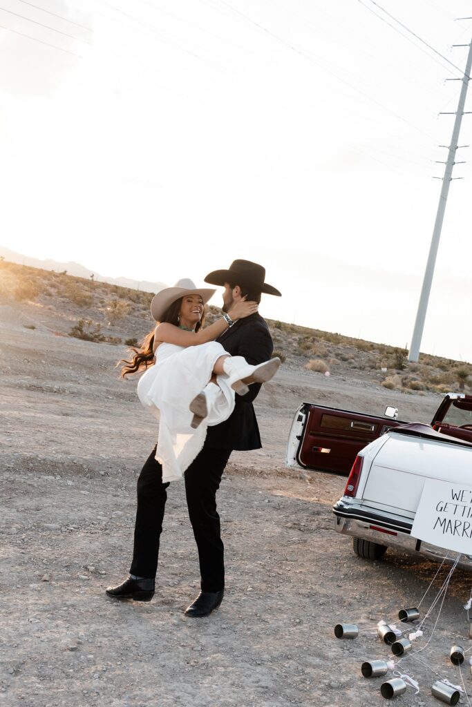 Man spinning his fiancé around during their desert western engagement photos in Las Vegas