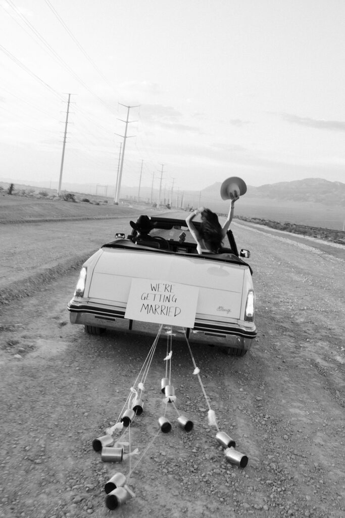 Black and white Las Vegas wedding announcement photos with a car and a "We're Getting Married" sign on the back