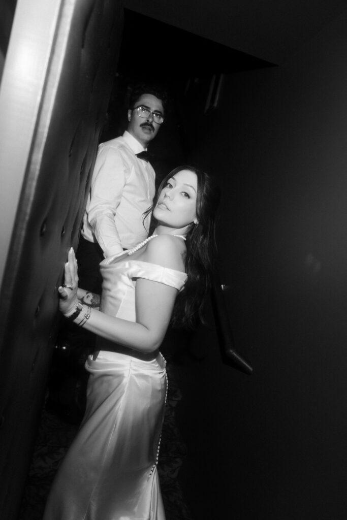 Bride and groom posing for a black and white portrait inside Doberman Drawing Room.