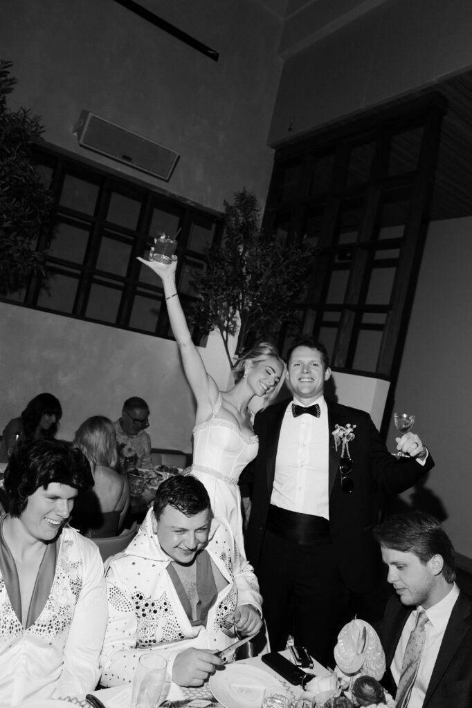 Bride and groom toasting with guests during their Las Vegas elopement dinner.