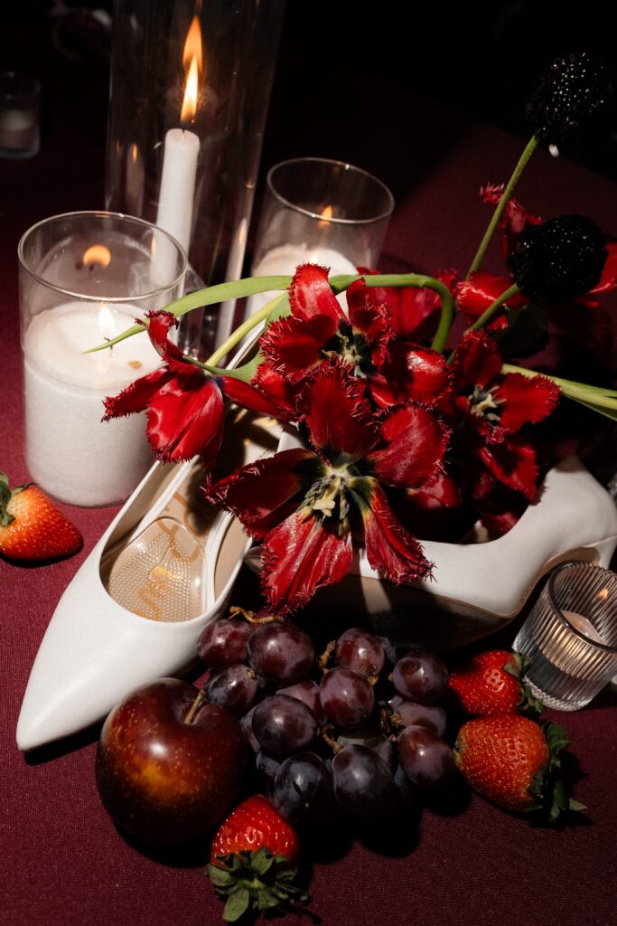 Las Vegas wedding reception details with fruit, shoes, and candles.