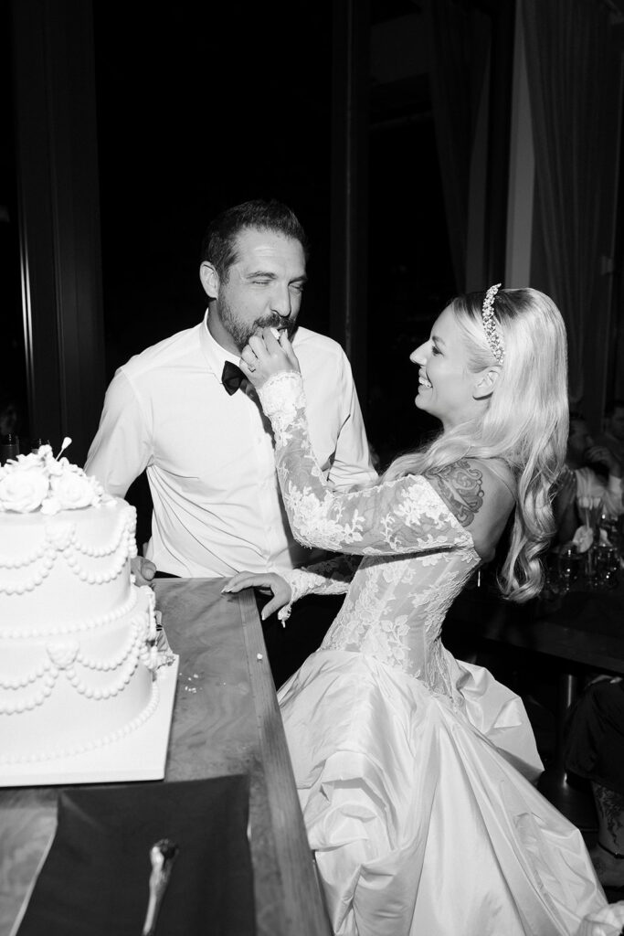 Bride feeding groom cake during La Cave Las Vegas wedding reception.