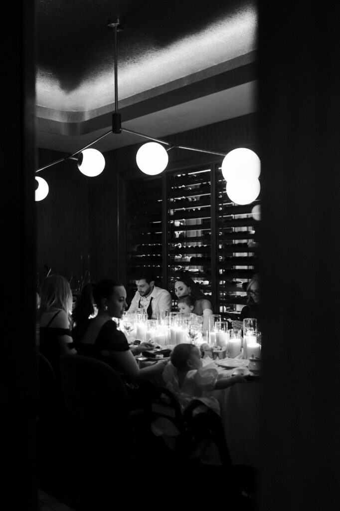 Black and white photo of family having an intimate dinner at Barry's Prime in Las Vegas for a micro wedding reception.