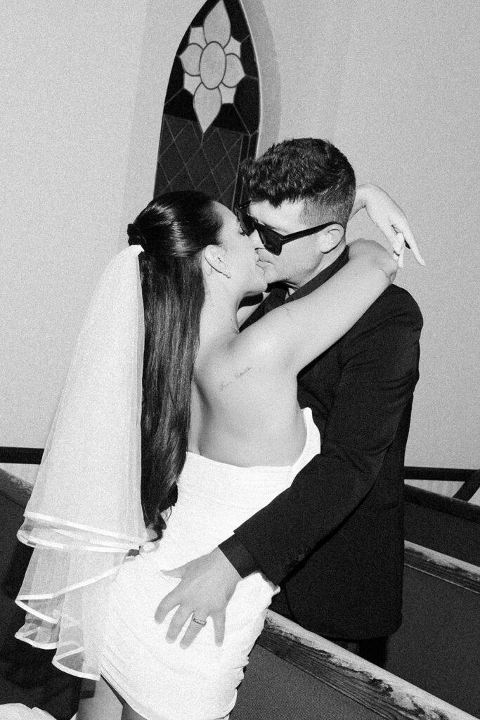 April Love Geary and Robin Thicke kissing in the pews at A Special Memory Wedding Chapel in Las Vegas