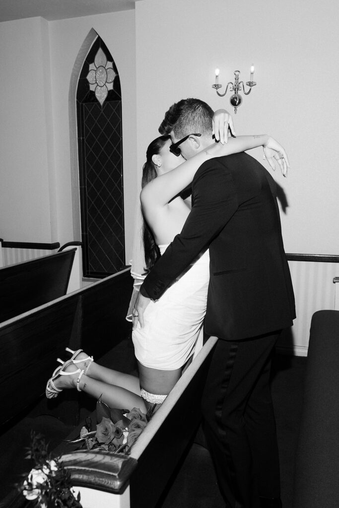 April Love Geary and Robin Thicke kissing in the pews at A Special Memory Wedding Chapel in Las Vegas