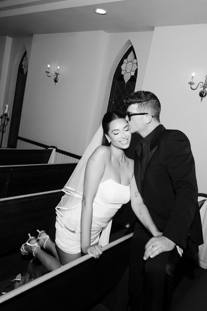 April Love Geary and Robin Thicke kissing in the pews at A Special Memory Wedding Chapel in Las Vegas