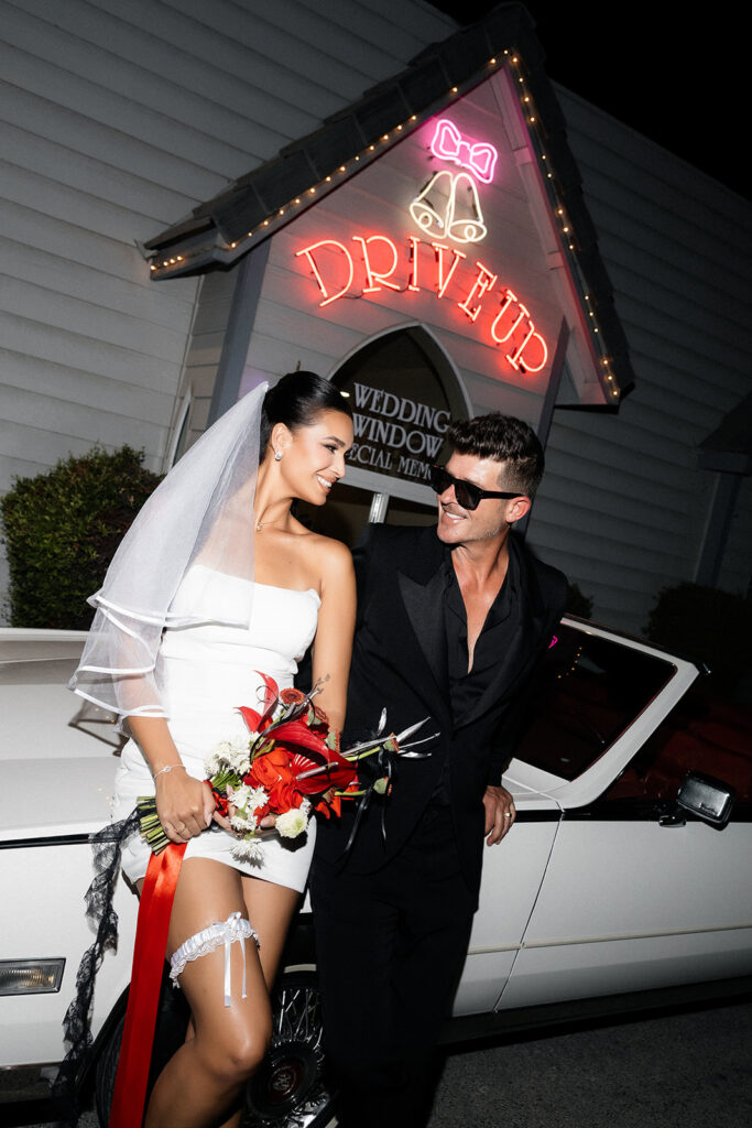 Robin Thicke and April Love Geary posing in front of A Special Memory Wedding Chapel
