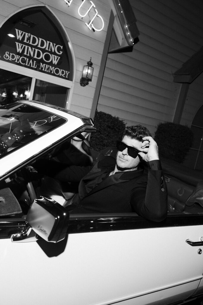 Robin Thicke posing in a classic white car at A Special Memory Wedding Chapel