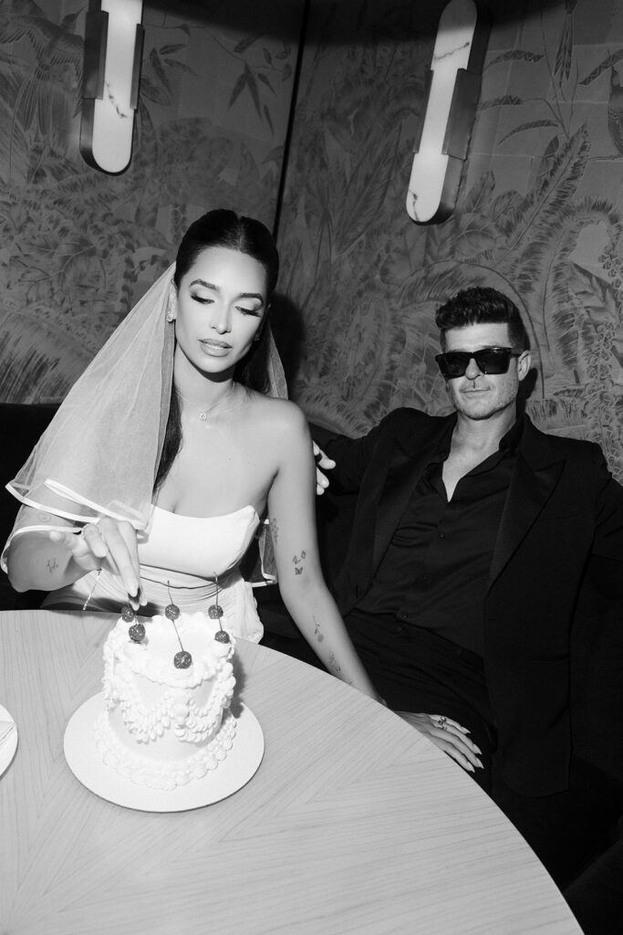 April plucking a cherry off of their Las Vegas elopement cake made by Winston Marie Cakes