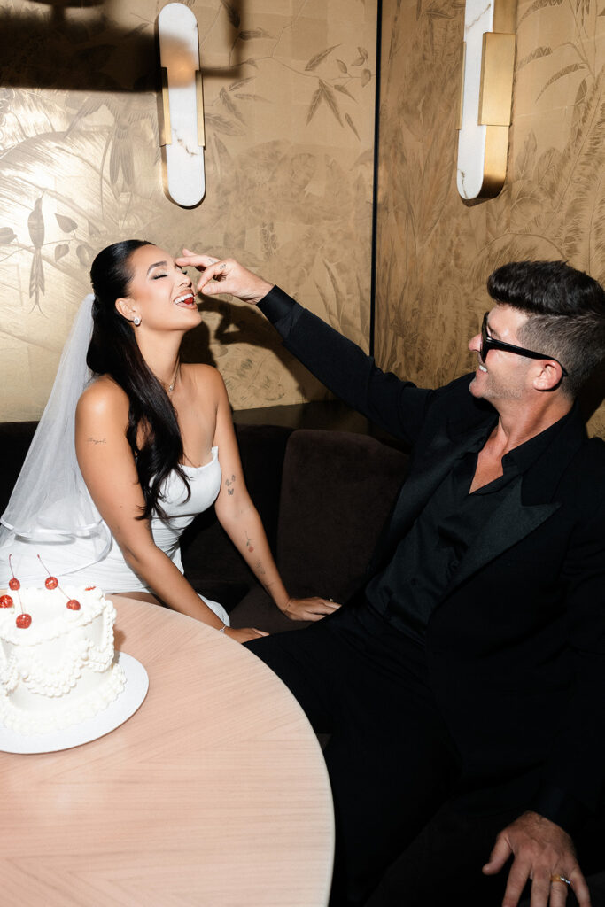 Robin feeding April a cherry from their Las Vegas elopement cake made by Winston Marie Cakes