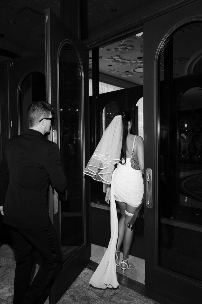 Bride and groom walking back into their hotel