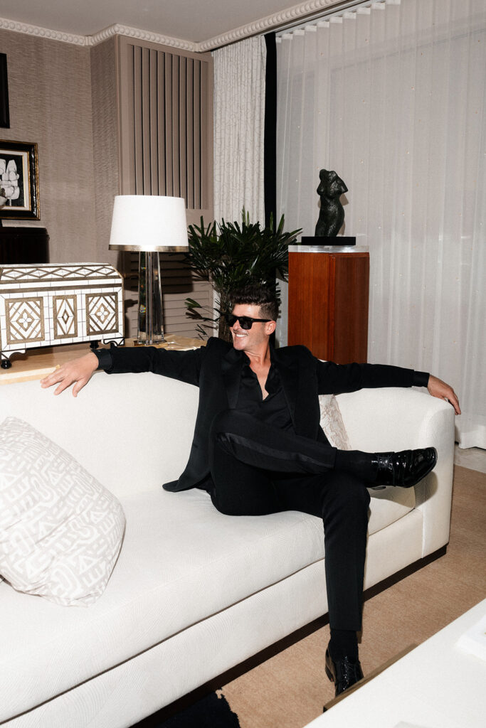 Robin Thicke sitting on his hotel couch during his Las Vegas elopement photoshoot