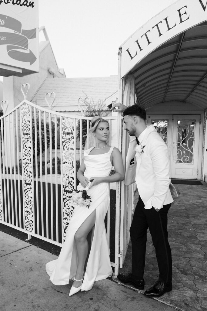 Black and white photo of a bride and groom posing for their classy elopement in Vegas at a Little White Chapel. 