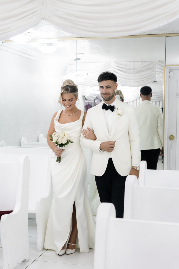 Bride and groom walking down the aisle together arm in arm for their classy elopement in Vegas.