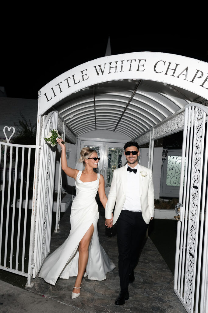 Flash photo of a bride and groom walking out of The Little White Chapel after their classy elopement in Vegas.
